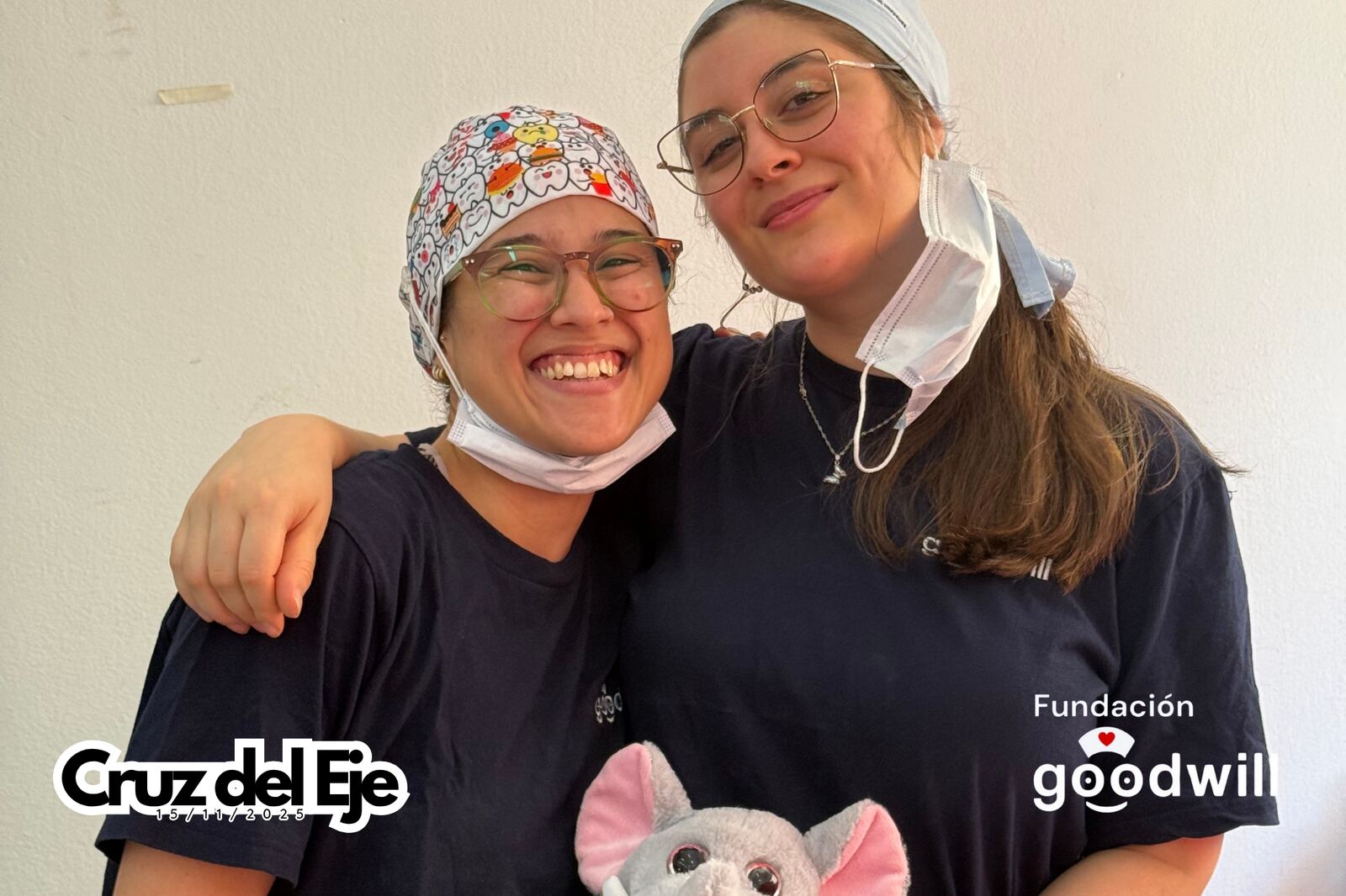 Dos odontólogas jóvenes abrazadas, con los gorros quirúrgicos puestos.